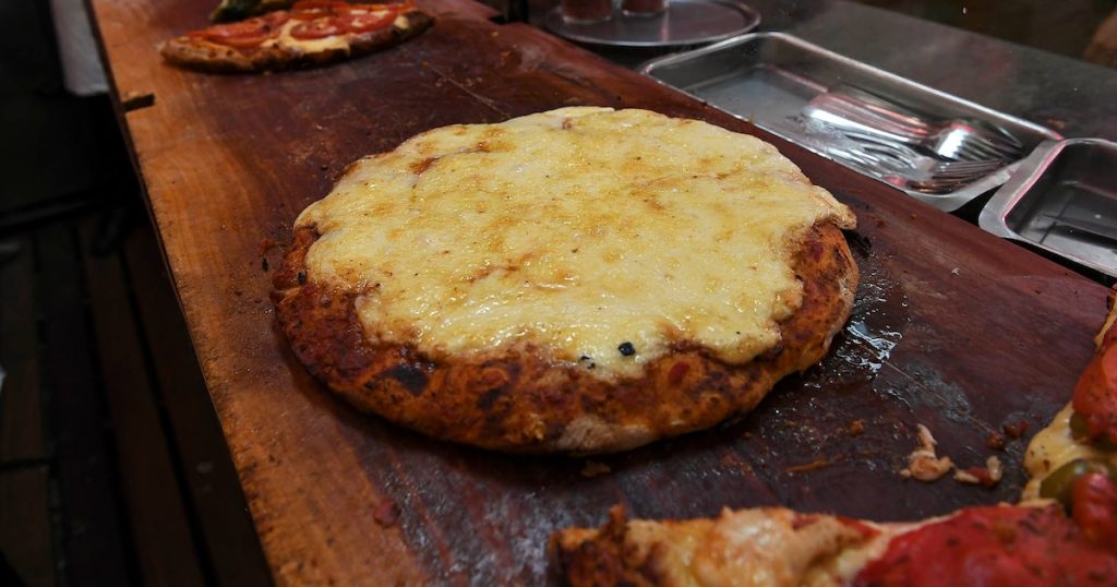 Fue a una emblemática pizzería porteña, pidió una pizza de muzzarella chica, faina y cerveza: el ticket se viralizó